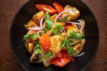 Colorful mix of vegetables served in a dark bowl, topped with fresh cilantro and sesame seeds