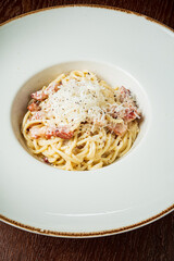 A delicious pasta dish topped with cheese served in a modern bowl at a fine dining establishment