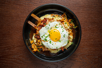A delicious breakfast of creamy mashed potatoes topped with tasty ingredients and egg