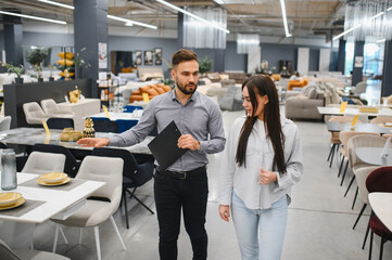 Sales consultant assisting client in furniture store showroom