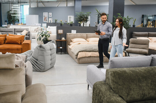 Fototapeta Client and sales consultant discussing options in furniture store showroom