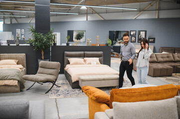 Sales consultant guiding potential buyer in furniture store