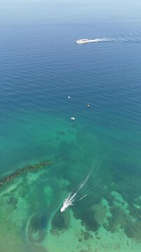 
A peaceful scene of a small boat sailing on calm blue sea under clear sky. Gentle waves sparkle in the sunlight, creating a serene and relaxing atmosphere. Ideal footage for travel videos, nature bac