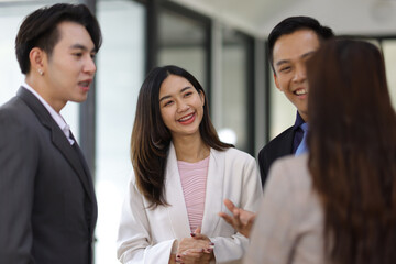 Coworkers standing and talking in the office.