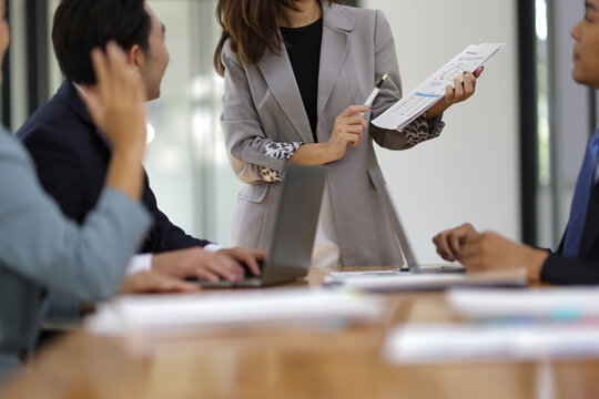 Asian businesswoman leader discussing business planning idea presentation with colleagues in conference room at office. - Powered by Adobe