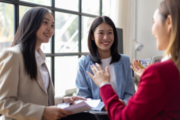 Group of young Asian businesswoman talking in the office. Working with happy coworkers meeting and discussing in the office.