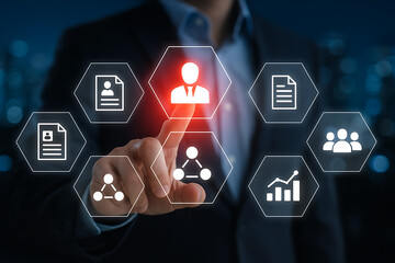 Business man touching virtual screen selecting a glowing red icon representing a central employee or human resource management system surrounded by other business and hr functions icons