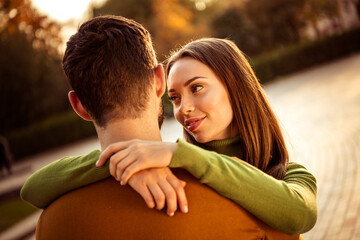 Romantic couple enjoying a fall day outdoors, woman embracing man with happiness and warmth