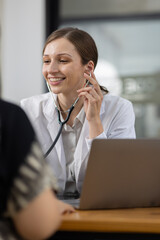 Doctor examining patient using stethoscope in hospital office. Female doctor listens to a patient's heartbeat with stethoscope during medical exam. She focuses on heart and lung health, care expertise
