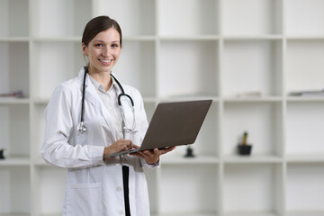 Online health advisory ideas from expert doctors. Confident female doctor in modern clinic with laptop, ready to provide healthcare. Professional atmosphere with modern technology and online services.
