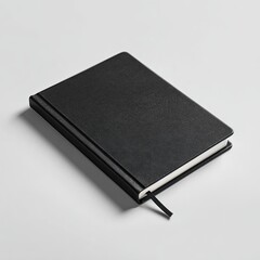 Black leather-like notebook on a light gray surface