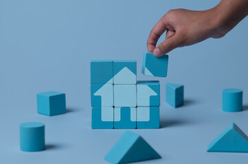 Hand building house with wooden blocks