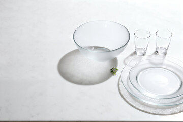 Translucent Glass Tableware on White Marble with Dramatic Shadow