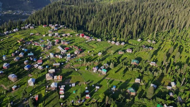 Aerial View of Arang Kel, Azad Kashmir &mdash; Scenic Mountain Village Surrounded by Lush Green Terraces, Dense Pine Forests, and Majestic Peaks under Clear Evening Light