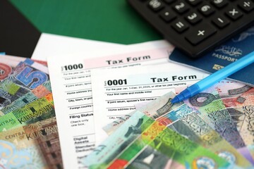 Kuwaiti dinar money bills and calculator with tax form on flag. Taxation and accounting concept