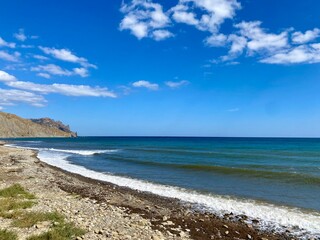 Beautiful beach background with waves and clouds. Natural landscape with empty beach.