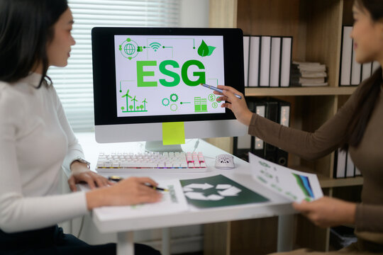Business women analyzing ESG sustainability report on computer