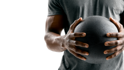 Focused african american man holding medicine ball preparing for fitness workout. Strength and exercise for health