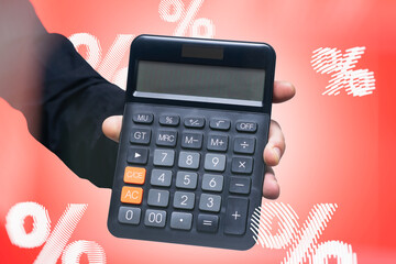 Businessman holding a calculator with percent signs. Finance concept, loans, interest rates, banking, investment, mortgage and accounting.