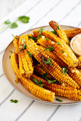 Homemade Spicy Corn Ribs with Mayo on a Plate, side view.