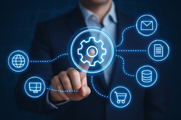 Business process automation concept a businessman touching a glowing gear icon connected by lines to various other icons representing global data email documents and e-commerce