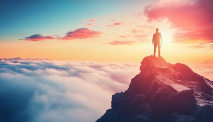 A silhouette of a man is standing on a rocky mountain peak above a sea of clouds during a vibrant sunset, the sky displays warm colors.