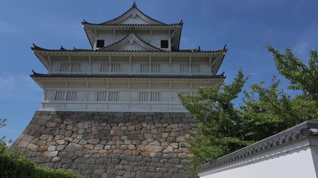 Fushimi Yagura of Fukuyama Castle (Japan's Top 100 Castles), a massive multi-layered defensive structure on towering stone foundations, shows majesty under the clear blue sky.