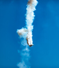 An aerobatic pilot in an aerobatic propeller plane shows off his