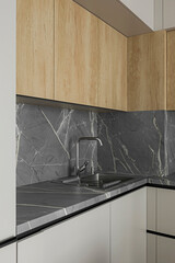 Grey table top, stainless steel sink with water tap, against a grey wall, minimalistic kitchen cabinets