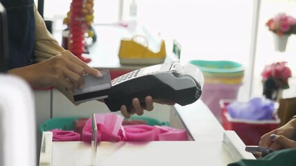 consumer paying item on grocery store checkout counter with credit card