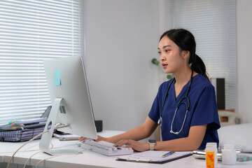 Female Asian doctor using computer in clinic office
