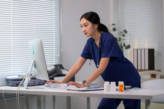 Nurse working on computer in medical office updating patient records