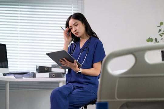 Female Doctor experiencing stress and burnout working in hospital