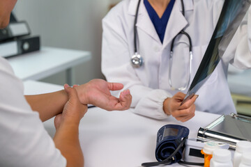 Doctor discussing wrist x-ray with patient during consultation