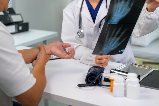 Doctor explaining x-ray to patient having wrist pain