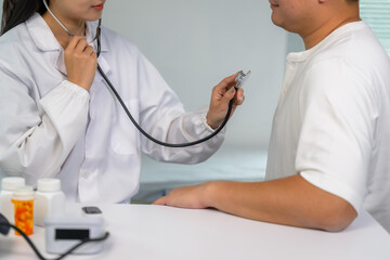 Doctor examining patient using stethoscope at medical check-up
