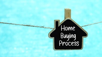 HOME BUYING PROCESS symbol on a mini whiteboard. Light blue background.