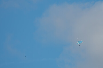 parachuter descending with blue sky and white clouds in the background in Salisbury Wiltshire England