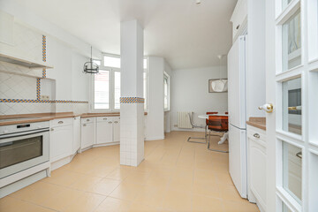 Contemporary kitchen with bottle-green panels, brass accents, and floating shelves for displaying dishes