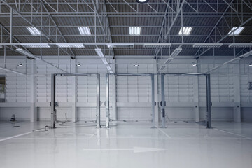 Modern auto repair shop interior with lift, tools, and clean floor.