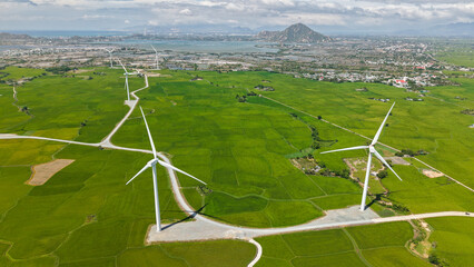 Green rice fields with wind turbines in rural Ninh Thuan, Vietnam. Royalty high-quality free best...