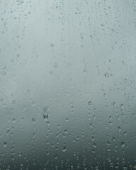 Close-up of raindrops on a window glass on a very cloudy day