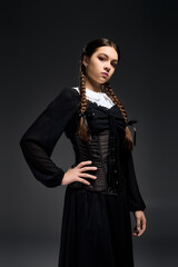 Girl in gothic dress with braids embracing spooky vibes for Halloween season