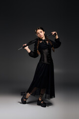 Girl in gothic dress paying homage to a classic spooky character for Halloween