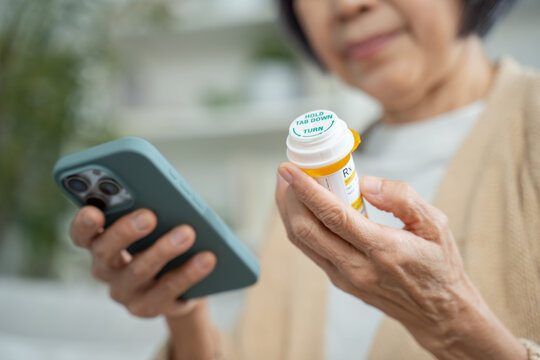 asian senior woman using smartphone searching prescription on bottle medicine,pill label about information online and video call with doctor.Health care technology and telemedicine telehealth concept
- Powered by Adobe
