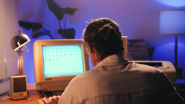 Man working and gaming on retro computer PC, IT engineer with vintage computer at home, using old fashion technology, close up of retro setup. 