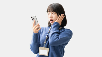 スマートフォンを見て驚く女性・ビジネスウーマン