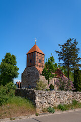 Fototapeta premium Eine massive Feldsteinmauer umgibt die denkmalgeschützte Dorfkirche 