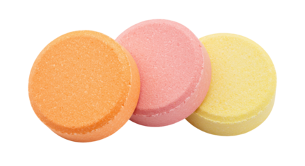 Three colorful effervescent tablets isolated on transparent background, orange pink and yellow fizzy vitamin pills for health and wellness