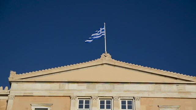 Athens, Greece: Building of Hellenic Parliament. Flag of Greece at the Parliament of Greece. Old Royal Palace on Syntagma square, the current seat of the Greek Parliament. 